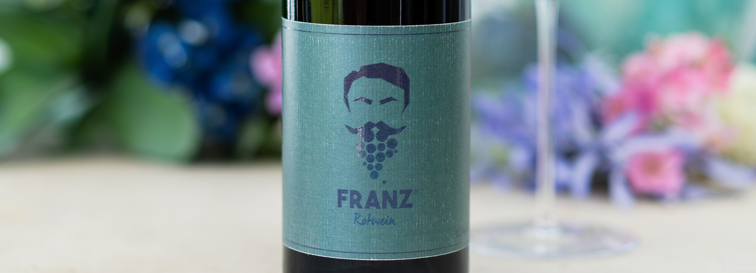 Franz Rotwein Flasche mit Blumen im Hintergrund