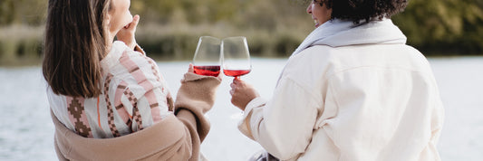 Zwei Freundinnen, die mit Traubensecco in Weingläsern anstoßen