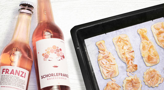 Mandelplätzchen auf Backblech neben Schorlefranzi Roséschorle
