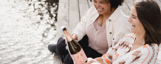 Zwei Freundinnen, die eine Flasche Franzi Pinot Blanc Sekt öffnen
