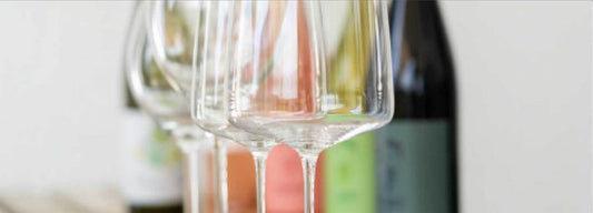 Weingläser mit Franz Weinflaschen im Hintergrund