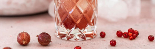 Cocktailglas mit Schorlefranz Weißweinschorle, Stachelbeeren und Johannisbeeren