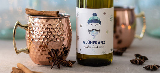 Glühfranz weißer Glühwein mit Kupfertassen und Zimtstangen