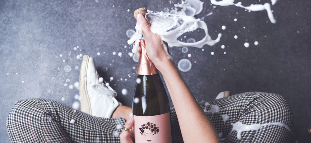 Geöffnete Franzi Pinot Blanc Sekt Flasche, aus der Schaum sprudelt